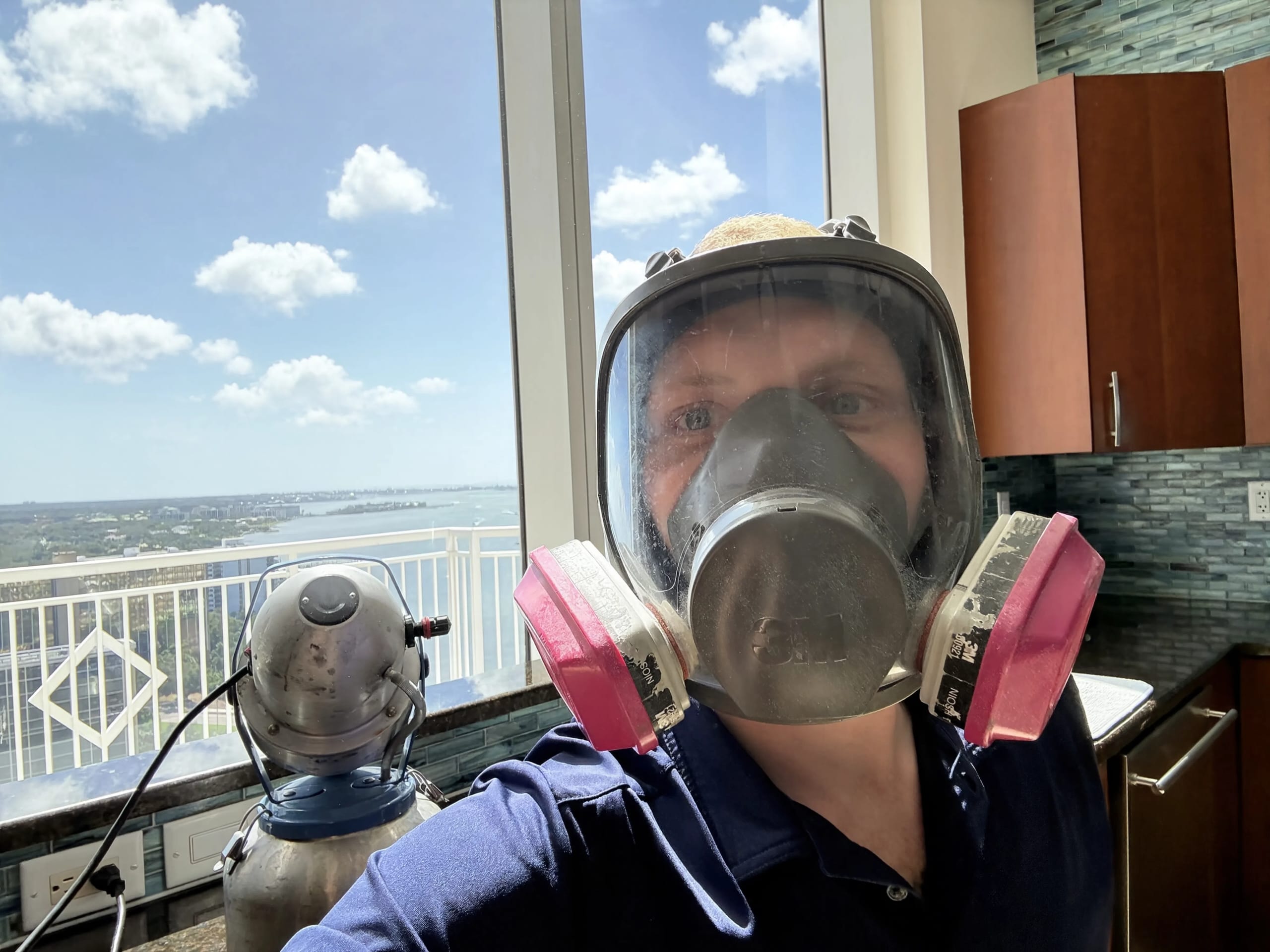 A technician wearing a full-face respirator on site
